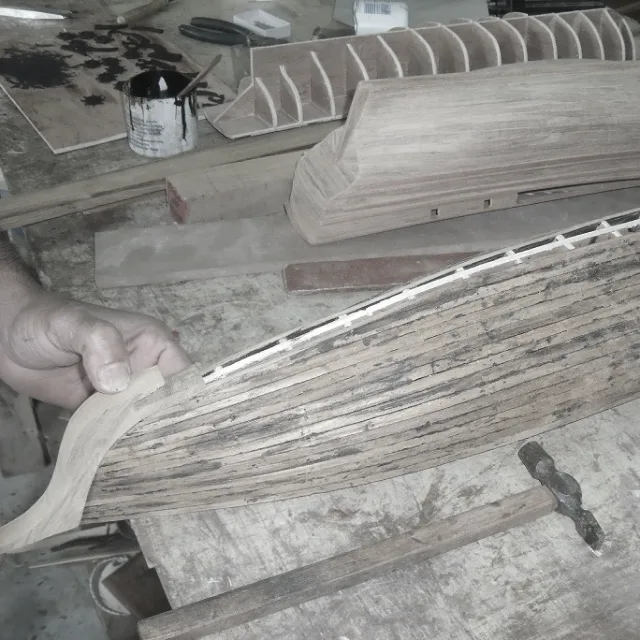 Artisan working on a handcrafted ship model in Mauritius